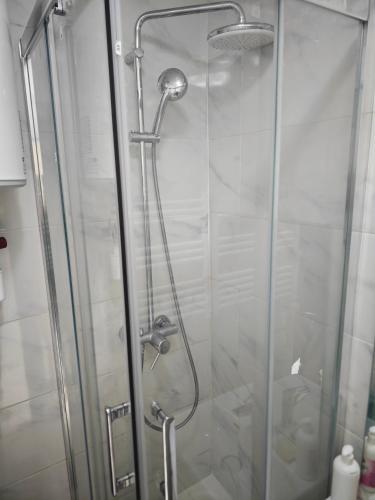 une douche avec une porte vitrée dans une salle de bain dans l'établissement Le Anatole, à Aubervilliers