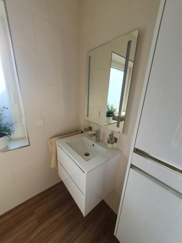 a white bathroom with a sink and a mirror at FeWo Francis in Scheeßel