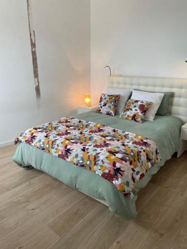 une chambre avec un lit avec une couette colorée dans l'établissement 3 min du parc du PUYDUFOU Centre des Epesses logement 4 à 6 personnes, L Ecrin du Puy, aux Épesses