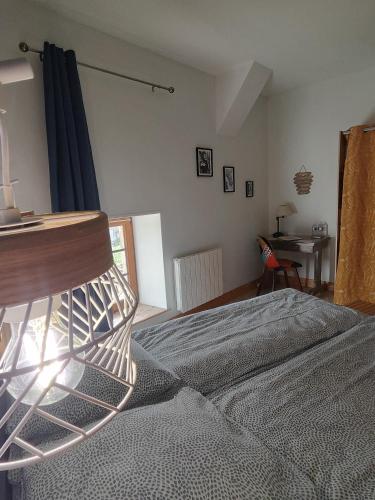 a bedroom with a bed and a desk at La ferme aux chats in Formigny
