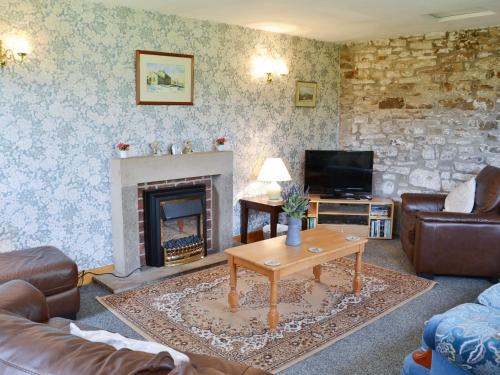 ein Wohnzimmer mit Couch und Kamin in der Unterkunft Yarker Lane Cottage in Mickleton