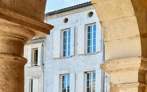 un bâtiment avec des fenêtres et des colonnes devant lui dans l'établissement Maison de ville au coeur d'une bastide historique, à Monségur