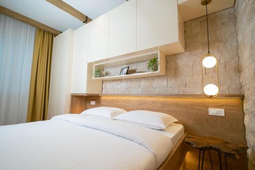 a bedroom with a large white bed with two pillows at 42° North Apartments in Tivat