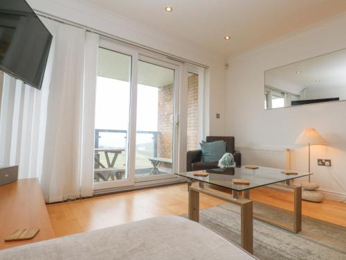 a living room with a table and a large window at 9 Headland Point in Newquay