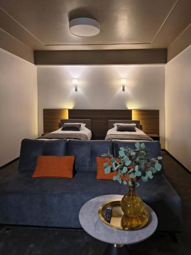 a living room with a blue couch and two beds at Mini Hotel on Brovarskaya in Kyiv