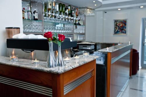a bar with roses in a vase on a counter at Hotel Croatia in Zagreb