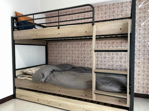 a wooden bunk bed with a ladder and a bedsheet at YS Miyazaki No, 302 - Vacation STAY 18877 in Miyazaki