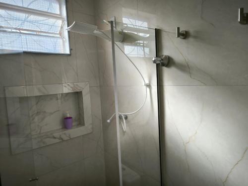 a shower with a glass door in a bathroom at Suites Duarte - Centro Histórico in Ouro Preto