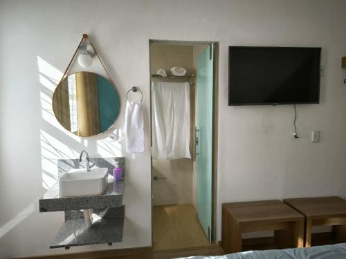 a bathroom with a shower and a sink and a mirror at Suites Duarte - Centro Histórico in Ouro Preto