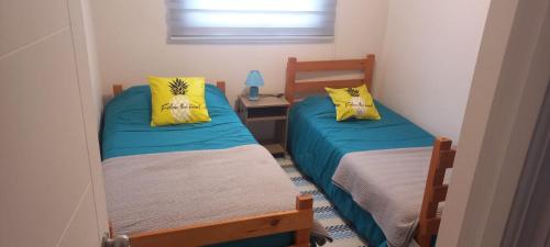 a bedroom with two beds and a window at Hermoso departamento en Serena a pasos de la playa y casino in Coquimbo