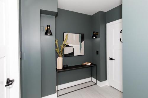 a hallway with green walls and a table and a mirror at Inn At Fulton Boutique Hotel in Sandusky