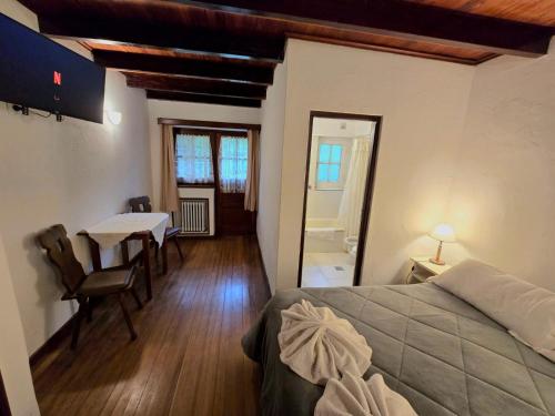 a bedroom with a bed and a table and a dining room at Hotel La Cumbrecita in La Cumbrecita