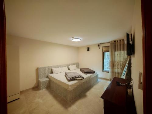 a bedroom with a bed and a television in it at villa white hall in Yehud