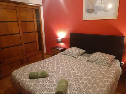 une chambre avec un lit et un mur rouge dans l'établissement Chambre d'hôtes petit déjeuner compris, à Carcassonne