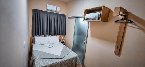 a small room with a bed and a tv at Hotel Parati in Parapuã