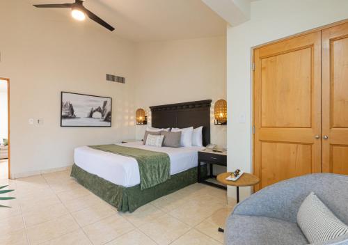 a hotel room with a bed and a couch at Hotel Tesoro Los Cabos in Cabo San Lucas