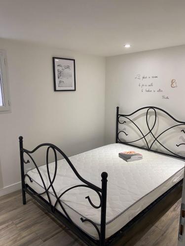 - une chambre dotée d'un lit avec un cadre noir dans l'établissement Joli appartement, à Aytré