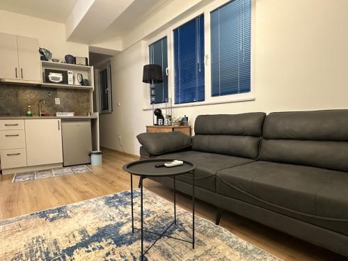 salon z kanapą i stołem w obiekcie Mamma Mia w mieście Skopje