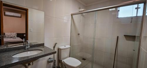 a bathroom with a toilet and a sink and a shower at Hotel Parati in Parapuã