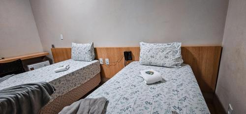 a small room with two beds in it at Hotel Parati in Parapuã