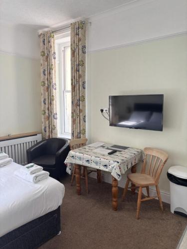 a hotel room with a bed and a table and a chair at Carnock in Tenby