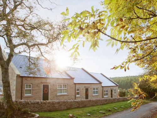 a house with a stone wall in front of it at Three The Old Stables in Knitsley