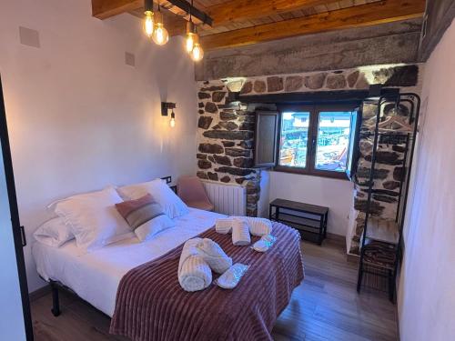 una camera da letto con un letto con due asciugamani sopra di 27A01 Casa Uría - Cam. Santiago a Berducedo