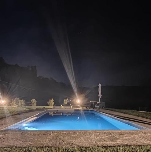 a large blue swimming pool at night with lights at Villa Grassi with private pool Nizza Monferrato in Calamandrana