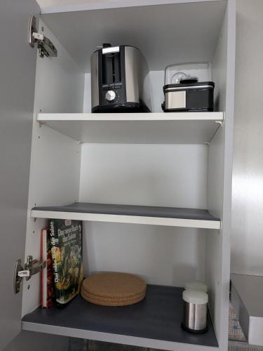a kitchen shelf with a toaster and a coffee maker at Mendiger Basalthaus in Mendig
