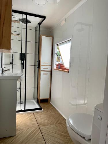 a bathroom with a toilet and a shower and a sink at Sonata Camp in Jastarnia