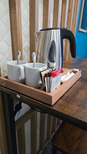 a coffee maker and two cups on a wooden tray at Pensjonat Lubianka in Starachowice