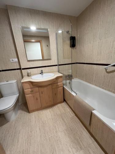 a bathroom with a sink and a tub and a toilet at Lujoso apartamento con piscina en Panorámica in Sant Jordi