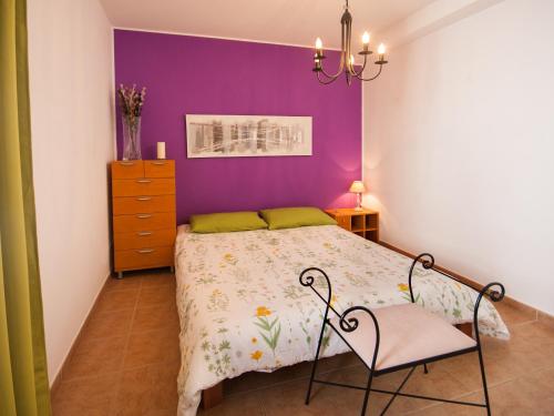 1 dormitorio con 1 cama con pared morada en Casa Claudia, en Teguise