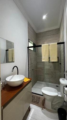 a bathroom with a sink and a toilet and a shower at Pousada Graboschii, 300mt da praia do Refúgio in Aracaju