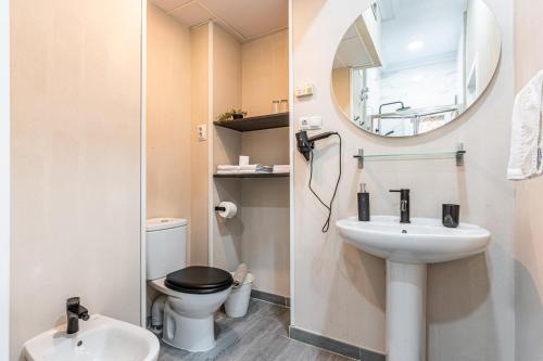a bathroom with a sink and a toilet and a mirror at Hotel Mexico in Madrid