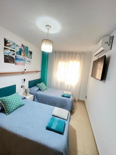 APARTAMENTO SITUADO EN EL CENTRO CON 3 HABITACIONES, DISPONE DE AIRE ACONDICIONADO Y WIFI A 150m DE LA PLAYA Y EL CASTILLO的电视和/或娱乐中心