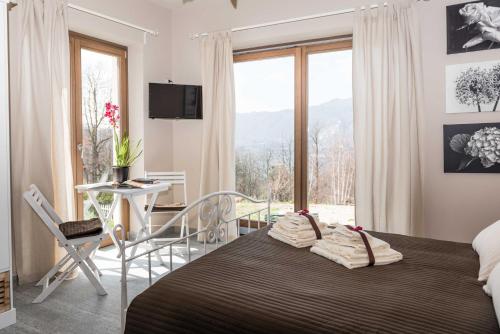 a bedroom with a bed and a large window at Lavanda e Rosmarino in Miasino