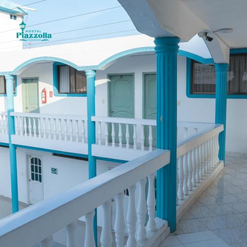 a balcony of a house with blue columns at HOSTAL PIAZZOLLA in Manta