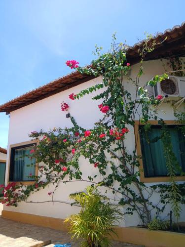 a house with flowers on the side of it at Pousada Graboschii, 300mt da praia do Refúgio in Aracaju