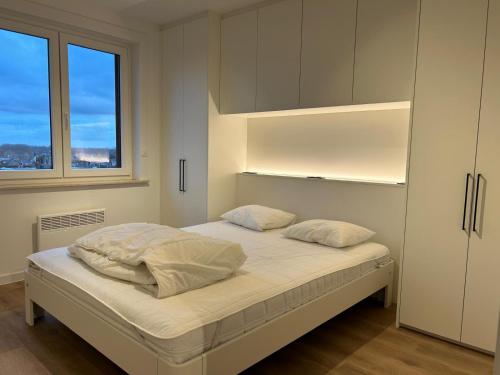 une chambre avec un lit avec deux oreillers dessus dans l'établissement Westende Zeezicht, à Middelkerke