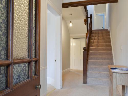 a hallway with a stairway with a door and a stairwayngth at The Birches in Keswick