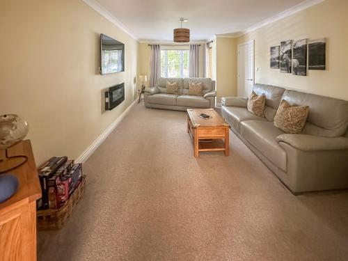 ein Wohnzimmer mit Sofa und Tisch in der Unterkunft West Fells Cottage in Arlecdon