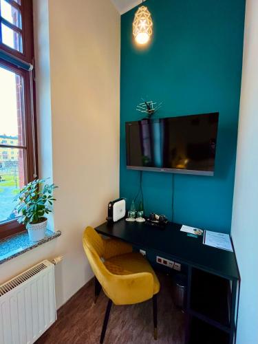 a desk with a yellow chair in a room at AmaMolto Train Station in Opole