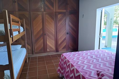 a bedroom with a bunk bed and a closet at Casa com Piscina Grande em Salinas in Salinópolis