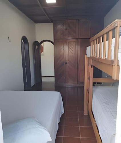 a bedroom with two beds and a bunk bed at Casa com Piscina Grande em Salinas in Salinópolis