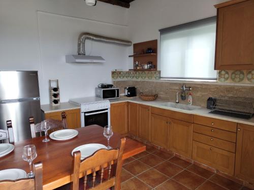 a kitchen with a wooden table with chairs and a sink at Sea Sight Vibes in Frangokastello