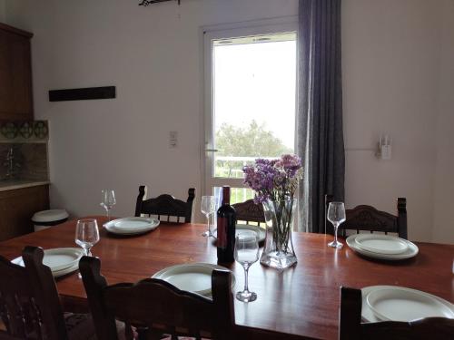 a dining room table with chairs and a large window at Sea Sight Vibes in Frangokastello