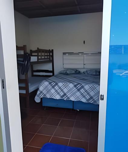 a small bedroom with a bed and a chair at Casa com Piscina Grande em Salinas in Salinópolis