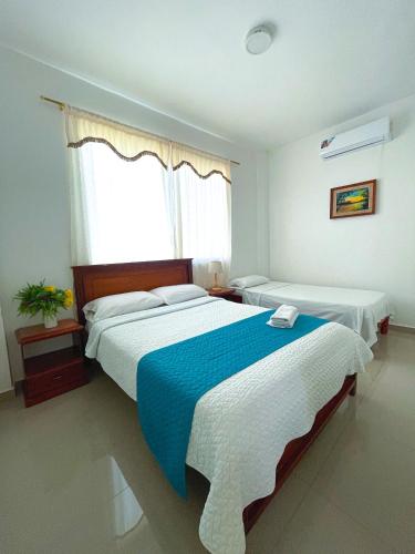 a bedroom with two beds and a window at HOSTAL PIAZZOLLA in Manta