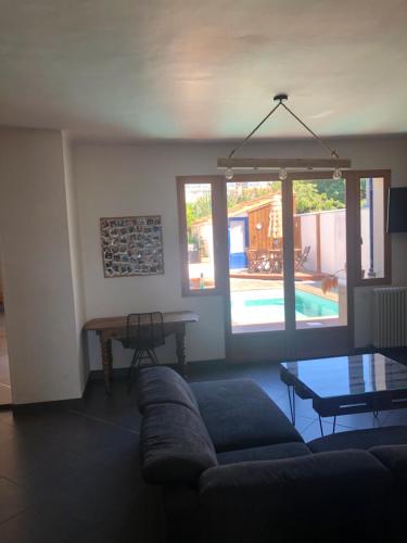 - un salon avec un canapé, une table et une piscine dans l'établissement MAISON SPACIEUSE LA ROCHELLE, à La Rochelle
